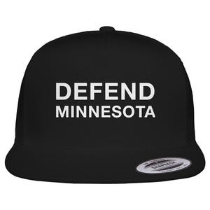 May include: Black trucker cap featuring the white text "DEFEND MINNESOTA". The cap has a curved peak and a mesh back, typical of this style of headwear.