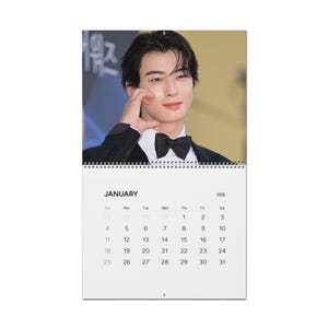 May include: A 2026 calendar with a photograph of a man in a black suit and bow tie. The calendar displays the month of January, with days and dates. The word "January" is printed in a bold font.
