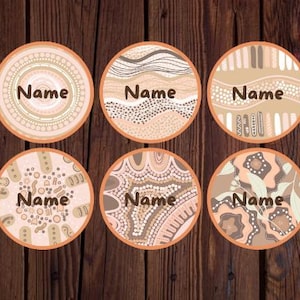 May include: Six round coasters with various abstract designs in shades of brown, beige, and orange. Each coaster has the word "Name" printed in the center. The coasters are displayed on a dark wood surface.