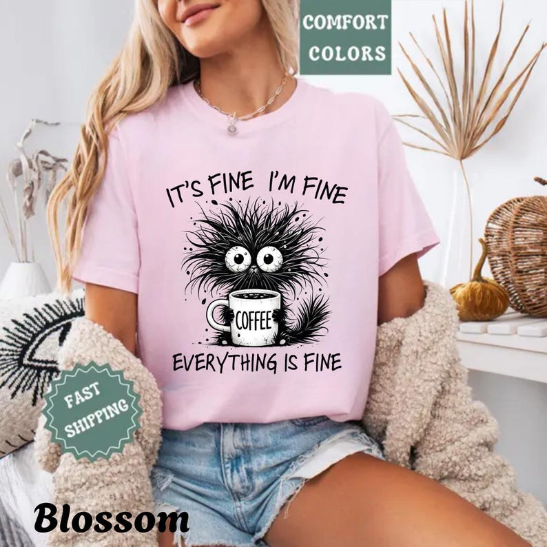 a woman wearing a pink shirt that says it's fine i'm fine