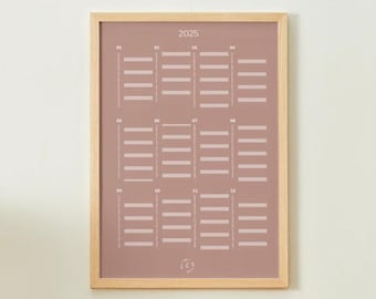 Puede incluir: Un calendario enmarcado de 2025. El calendario tiene un fondo rosa polvoriento con una cuadrícula de líneas horizontales que representan meses y fechas. El marco es de madera clara.