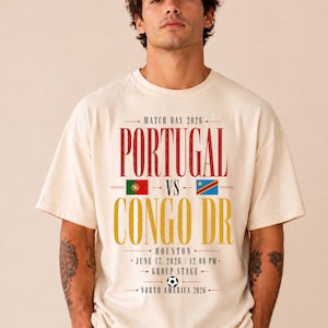 May include: A cream-coloured short-sleeve t-shirt featuring a graphic print that reads MATCH DAY 2026, PORTUGAL VS CONGO DR, HOUSTON, JUNE 17, 2026, 12.00 PM, GROUP STAGE, NORTH AMERICA 2026, with the flags of Portugal and Congo DR and a football.
