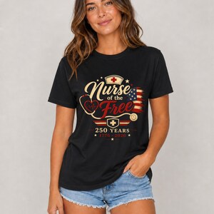 May include: Black t-shirt with the text "Nurse of the Free" in gold script, a red cross, and a stethoscope design. The shirt also features the American flag and the text "250 YEARS * 1776 - 2026 *."