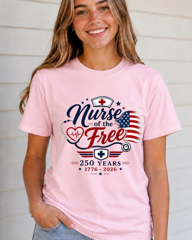 May include: A light pink t-shirt with the text "Nurse of the Free" in navy blue and red, with a stethoscope and American flag design. The shirt also features the text "250 Years 1776-2026".
