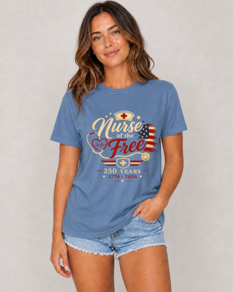 May include: A blue t-shirt with the text "Nurse of the Free" in gold script, featuring a red cross, a stethoscope, and an American flag design. The shirt also includes the text "250 YEARS 1776-2026".