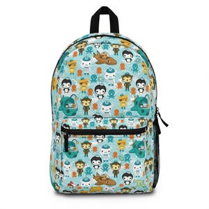 May include: A blue backpack with a black handle and zipper. The backpack features a repeating pattern of cartoon characters, submarines, and sea creatures on a wavy background. The backpack has a front pocket and a mesh side pocket.