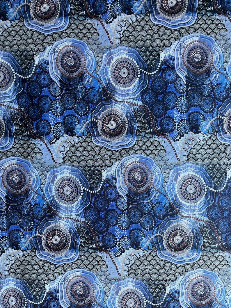 "Authentic Blue Water Dreaming Aboriginal fabric by Tamay Beam, featuring intricate saltwater coastal iconography and dot art in shades of indigo, sky blue, and grey on 100% cotton poplin."