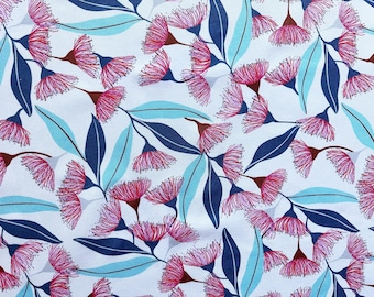 May include: A fabric pattern featuring a white background with a repeating botanical print of pink eucalyptus flowers and long, slender leaves in shades of dark navy blue and light cyan, arranged in a dense, overlapping floral composition.