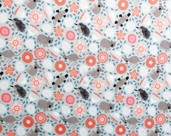 May include: Light blue fabric with a repeating pattern of gray koalas, kangaroos, echidnas, and platypuses. The design also includes orange and pink flowers, white leaf shapes, and blue leaves. This fabric is suitable for various craft projects.