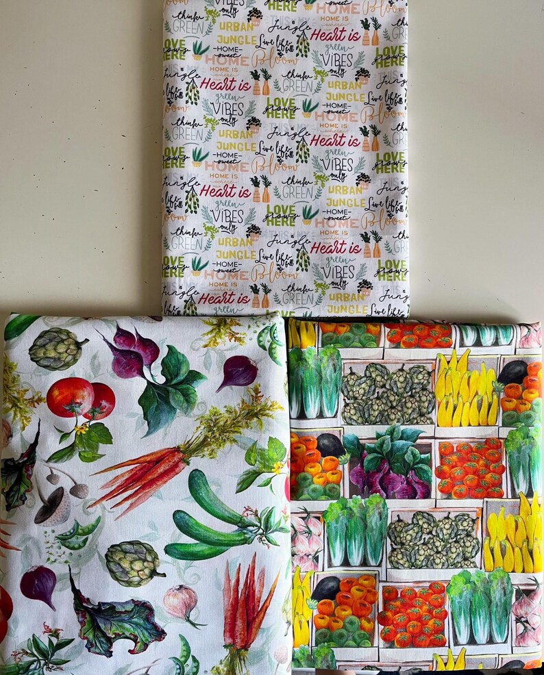 Op de afbeelding: Drie stukken stof met verschillende patronen. E&eacute;n stuk heeft de tekst "Heart is Home", "Green Vibes" en "Urban Jungle". De tweede heeft aquarel illustraties van groenten. De derde heeft illustraties van groenten in houten kisten.