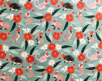 May include: A teal fabric with a repeating pattern of Australian animals wearing Santa hats. The animals include a koala, a kangaroo, a bandicoot, and an echidna. The pattern also includes red gum flowers and eucalyptus leaves.