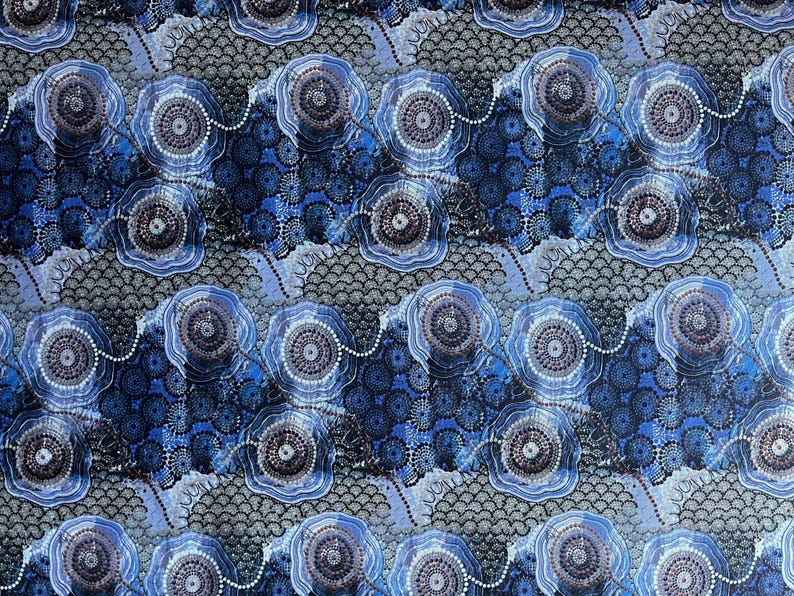 "Authentic Blue Water Dreaming Aboriginal fabric by Tamay Beam, featuring intricate saltwater coastal iconography and dot art in shades of indigo, sky blue, and grey on 100% cotton poplin."