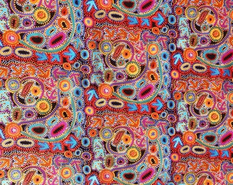 May include: A fabric featuring a dense, repeating pattern of colorful dots, concentric circles, and light blue arrows on a dark background. The design incorporates vibrant shades of orange, yellow, pink, purple, and teal, creating a complex, textured visual effect across the entire surface of the textile.