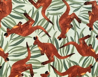May include: A repeating pattern featuring reddish-brown kangaroos in various poses against a backdrop of green and white foliage. The design has a whimsical, illustrative style, suitable for fabric or wallpaper.