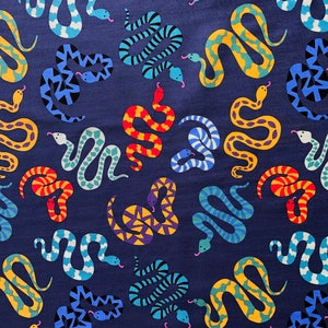 May include: A navy blue textile featuring a repeating pattern of colourful snakes. The snakes are in various colours, including yellow, blue, red, and purple, with details like forked tongues and scales. The overall design is a vibrant and eye-catching textile.