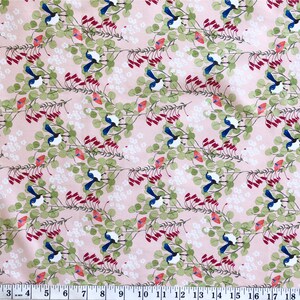 A close-up view of a premium pink cotton quilting fabric designed by Anne Waters. The fabric features a repeating pattern of small blue fairy wrens perched on delicate branches with green eucalyptus leaves and vibrant red Australian Christmas bell flowers.