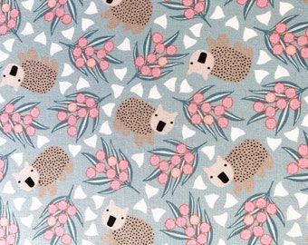 May include: A repeating pattern featuring stylized koalas with dotted bodies, pink berries, and green leaves on a light blue background. White triangular shapes are interspersed throughout the design. The overall aesthetic is whimsical and nature-inspired.