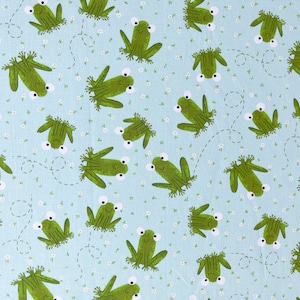 Peut inclure: Tissu bleu clair avec un motif répété de grenouilles vertes de dessin animé aux yeux blancs et de petites fleurs blanches. Les grenouilles sont dans diverses poses, certaines avec des lignes pointillées suggérant le mouvement. Idéal pour les projets de couture.