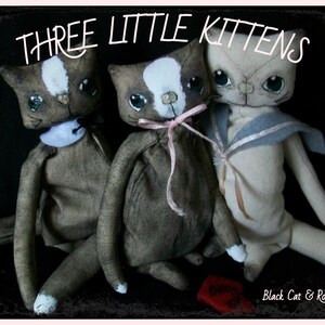 May include: Three handmade fabric kittens with black eyes and white markings. The kittens are wearing different outfits, including a sailor shirt and a pink ribbon. The image is titled "Three Little Kittens".
