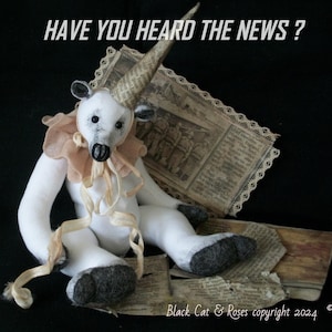 May include: White teddy bear with a black nose and black eyes wearing a brown and white fabric collar and a brown paper cone hat. The bear is sitting on a piece of paper with the text "HAVE YOU HEARD THE NEWS?" above it. The background is black.