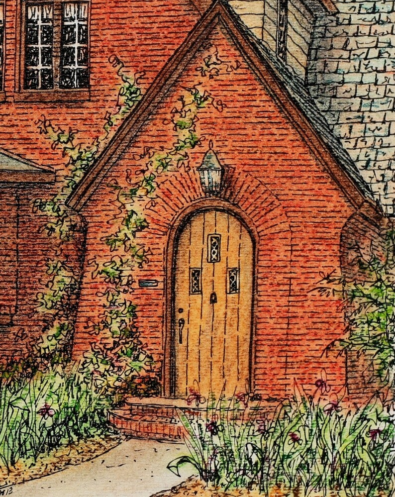 May include: A brick house with a wooden door and a vine growing up the side. The door has a small window with a decorative design. There are green plants and flowers in front of the house.