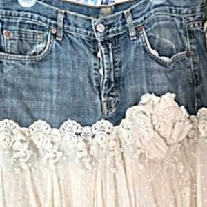 May include: A denim skirt with a light blue wash, featuring a white lace overlay at the hem. The skirt has classic five-pocket styling and a button-and-zipper closure. The lace adds a feminine touch to the casual denim.