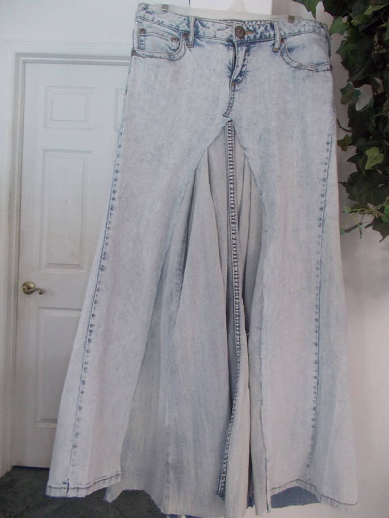 Puede incluir: Una falda maxi de mezclilla azul claro con una abertura en la parte delantera. La falda tiene un aspecto desgastado y est&aacute; hecha de una tela suave y c&oacute;moda.