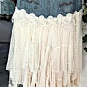May include: A denim skirt with a lace overlay. The skirt features the back pockets and waistband of a pair of jeans, with a cream-colored lace skirt attached. The lace has a tiered, ruffled design.
