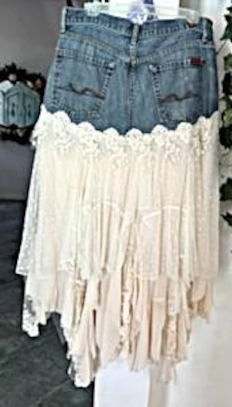 May include: A denim skirt with a lace overlay. The skirt features the back pockets and waistband of a pair of jeans, with a cream-colored lace skirt attached. The lace has a tiered, ruffled design.