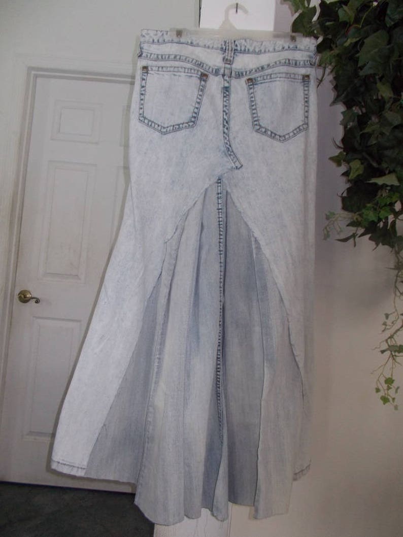 Puede incluir: Una falda vaquera azul claro con una abertura alta en la espalda. La falda est&aacute; hecha de una tela suave y c&oacute;moda y tiene un ajuste holgado.