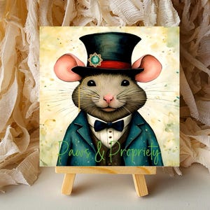 May include: A watercolor painting of a mouse wearing a top hat, bow tie, and a blue blazer. The image has the text "Paws & Propriety" in green script. The artwork is displayed on a small wooden easel.