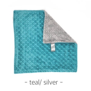 May include: Teal and silver minky dot baby blanket. The blanket is soft and cuddly, perfect for a baby or toddler.