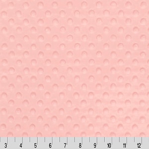 May include: A close-up of a pale pink fabric with a textured pattern of small raised circles.