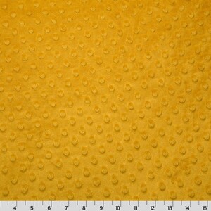 May include: A close-up of a yellow minky fabric with a textured dot pattern.