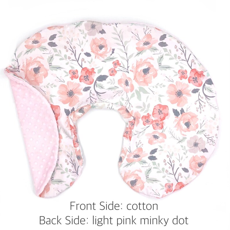May include: A U-shaped nursing pillow with a floral print on the front and a light pink minky dot fabric on the back.  Front Side: cotton. Back Side: light pink minky dot.
