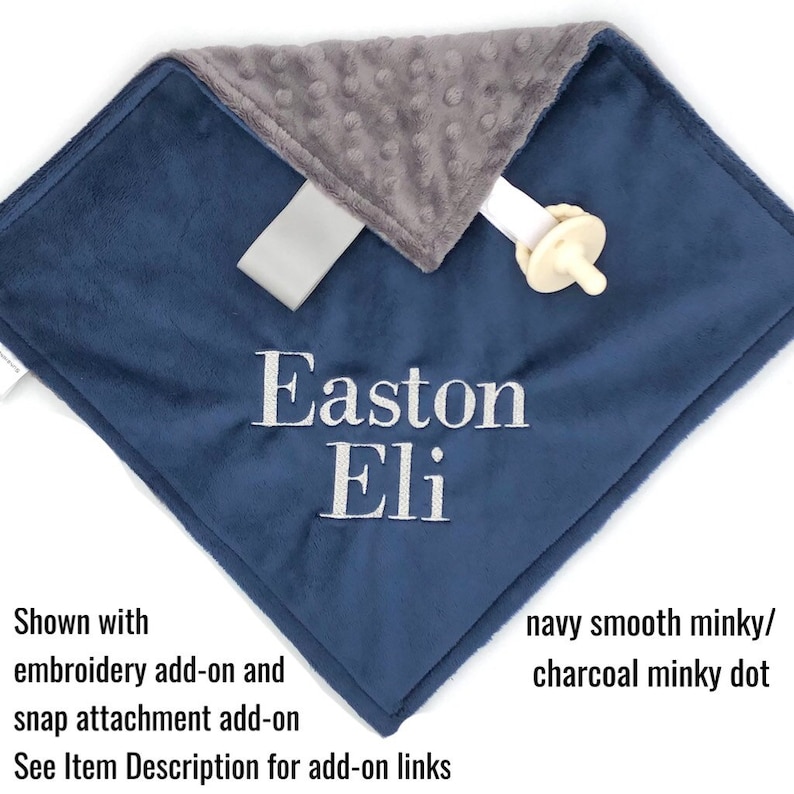 May include: A navy blue and charcoal gray minky baby blanket with the names "Easton Eli" embroidered in white.