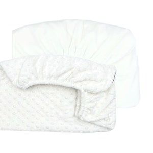 May include: White fitted crib sheet with a textured, quilted surface. The sheet is made of soft, breathable fabric.
