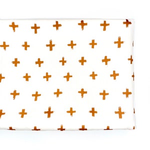 May include: White fabric with a repeating pattern of gold plus signs.