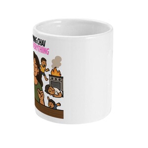 May include: White ceramic mug with a cartoon illustration. The mug features a woman with children and text that reads "Making Chai Fixes Everything". The illustration depicts a kitchen scene with a stove on fire.