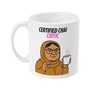 Op de afbeelding: Witte keramische mok met een handvat. De mok heeft een cartoon illustratie van een vrouw met een bril en hoofdbedekking, die een kopje koffie vasthoudt. De tekst "CERTIFIED CHAI CRITIC" is in zwart en roze gedrukt.