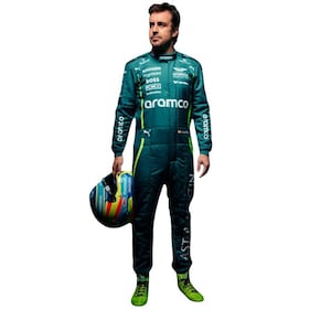 May include: A driver in a green racing suit with the words "Aston Martin" and "Aramco" on it. The driver is holding a blue and yellow helmet.