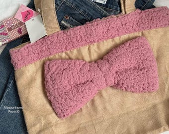 May include: A beige tote bag with a large pink bow and pink trim. The bag has beige handles and is placed on top of blue denim jeans. A tag is attached to the bag. The text "Meaaonhome From IG" is visible.