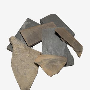 May include: A collection of irregularly shaped slate tiles in shades of gray and tan. The tiles vary in size and texture, with some appearing smooth and others rough. The arrangement suggests a natural, earthy aesthetic, suitable for home decor or craft projects.