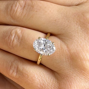 Könnte beinhalten: Ein goldener Ring mit einem großen ovalen Diamanten.