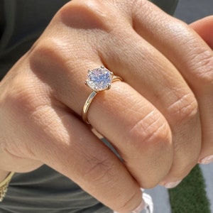 Op de afbeelding: Een gouden ring met een grote, heldere, ronde diamant.