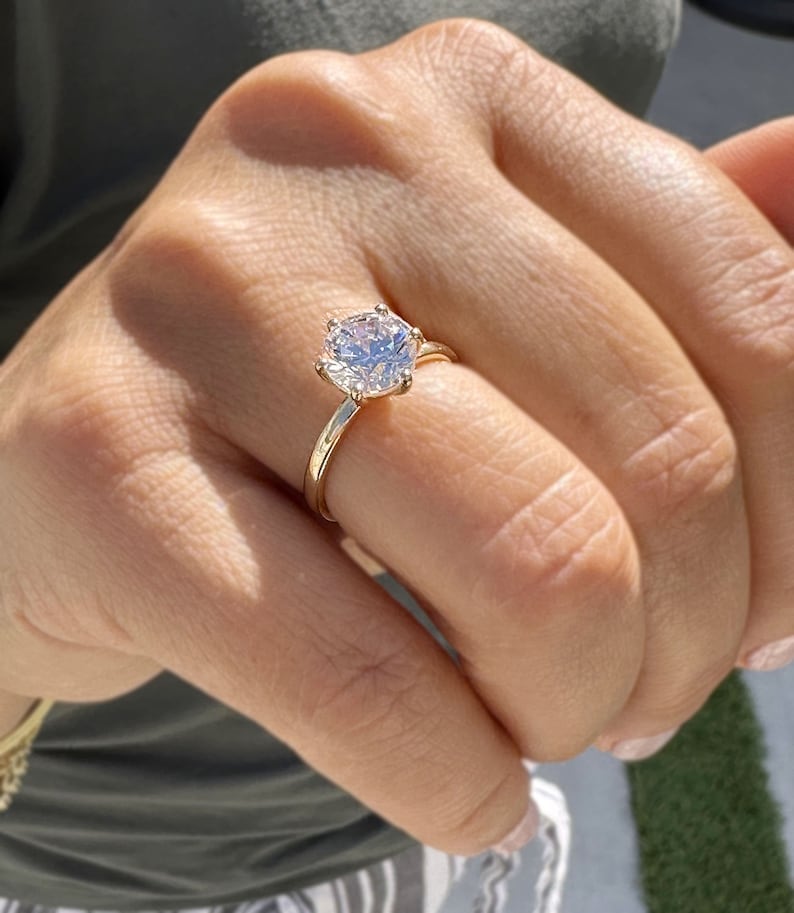 Op de afbeelding: Een gouden ring met een grote, heldere, ronde diamant.