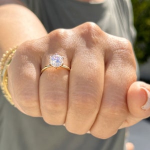 Op de afbeelding: Een gouden ring met een grote, heldere, ronde diamant.