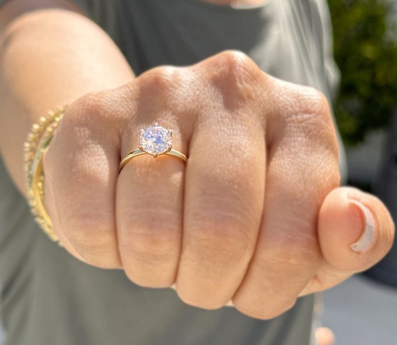 Op de afbeelding: Een gouden ring met een grote, heldere, ronde diamant.