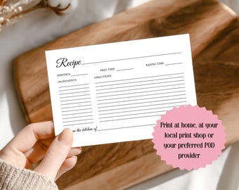 May include: A white recipe card with the word "Recipe" at the top, featuring spaces for servings, ingredients, prep time, directions, and baking time. The card is held by a person's hand and has a pink sticker that says "Print at home, at your local print shop or your preferred POD provider."