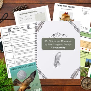 May include: A collection of educational materials for a book study, including a spiral-bound notebook with the title "My Side of the Mountain" and a book cover. Other items include worksheets, a compass, and a pinecone, all arranged on a wooden surface.